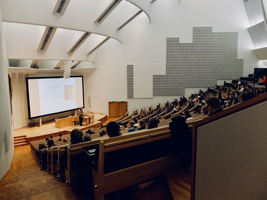 A hall filled with people demonstrating assisted listening device benefits