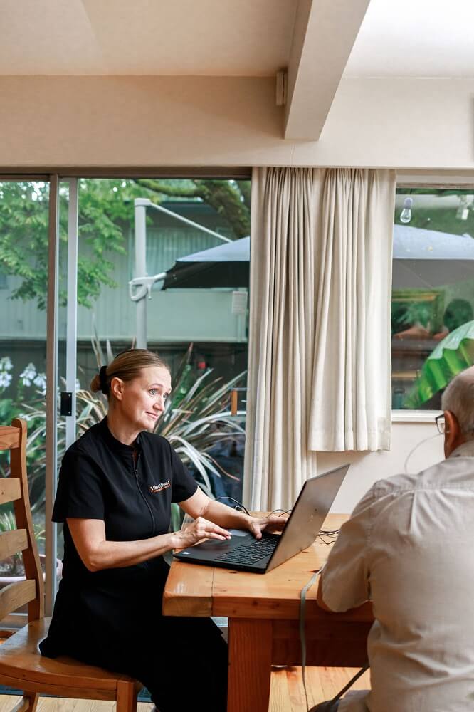 Hearing aid practitioner with a senior male client have a discussion