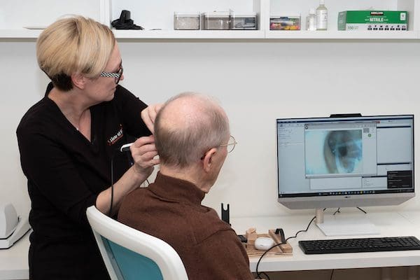 Jennifer Abbot, hearing aid practitioner performing hearing test